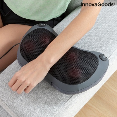 Almofada de massagem elétrica cinza e preta InnovaGoods num sofá cinza.