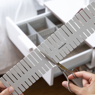 Organizador divisórias branco Innomac Goods sendo cortado com tesoura perante gaveta organizada