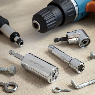 Furadeira azul e laranja com acessórios metálicos prateados sobre madeira