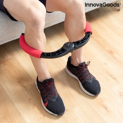 Aparelho de exercício para pernas com almofadas vermelhas usado por pessoa sentada numa sala com chão de madeira