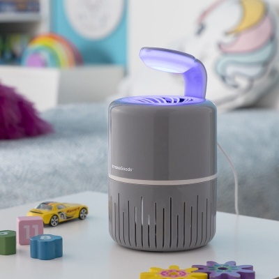 Dispositivo elétrico cinza com luz azul em mesa com brinquedos coloridos
