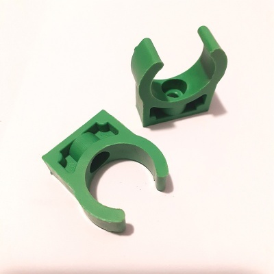 Dois suportes ou clipes verdes em plástico sobre fundo branco