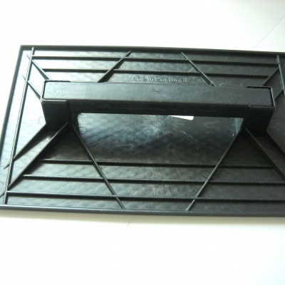 Suporte preto retangular com alça no centro e padrões geométricos