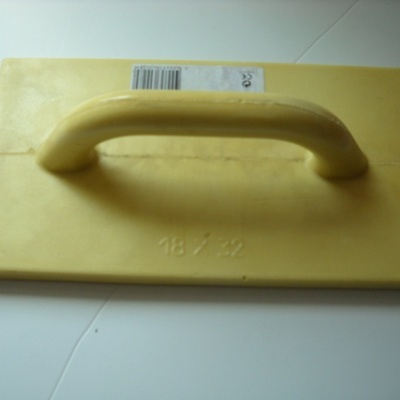 Flutuador amarelo de plástico com pega em cima sobre superfície branca