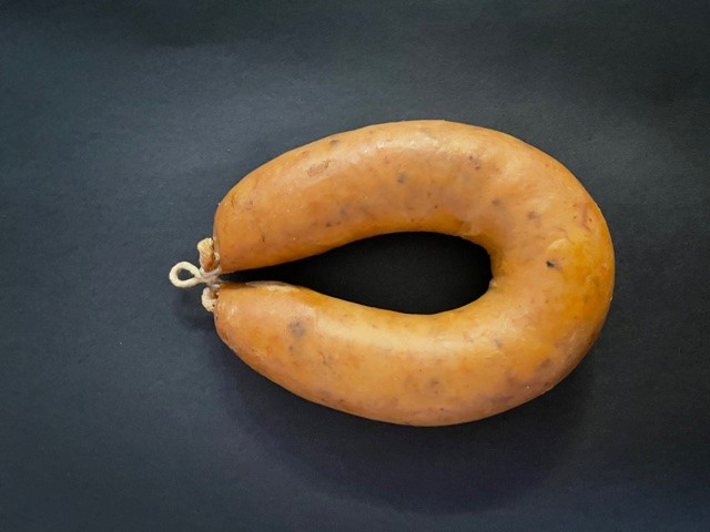 Alheira com Cogumelos Chouriço em ferradura sobre fundo preto