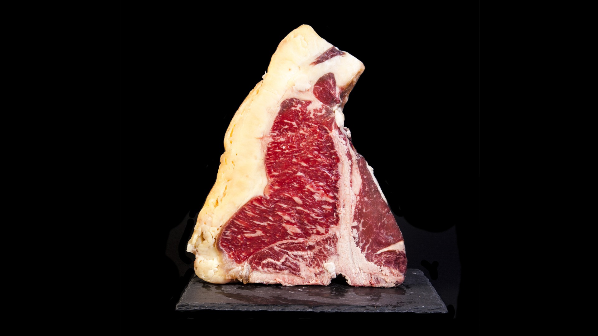 T-BONE Rubia Gallega Pedaço de carne T-bone crua com gordura em fundo preto