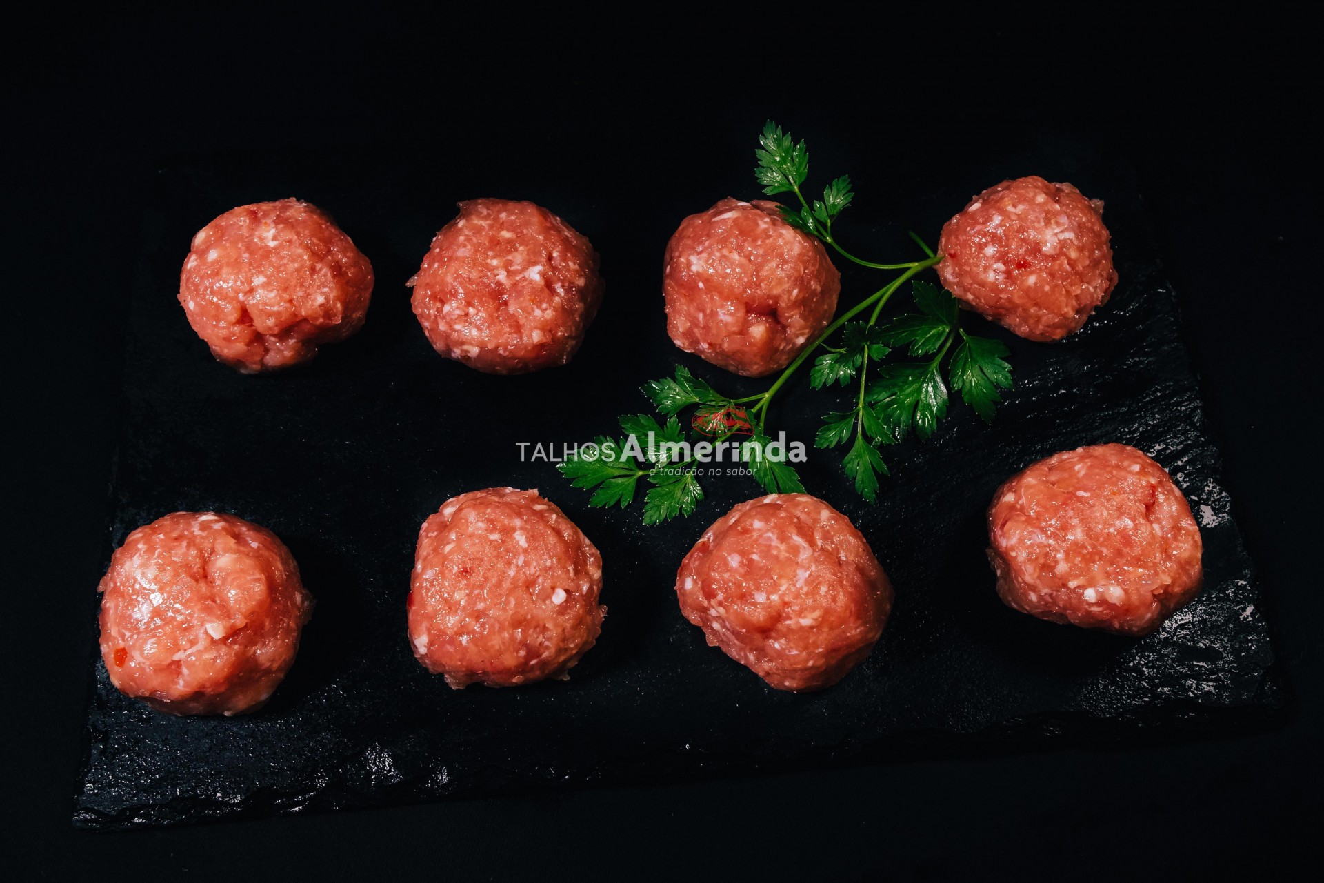 Almôndegas De Aves Bolas de carne crua com salsa sobre placa preta