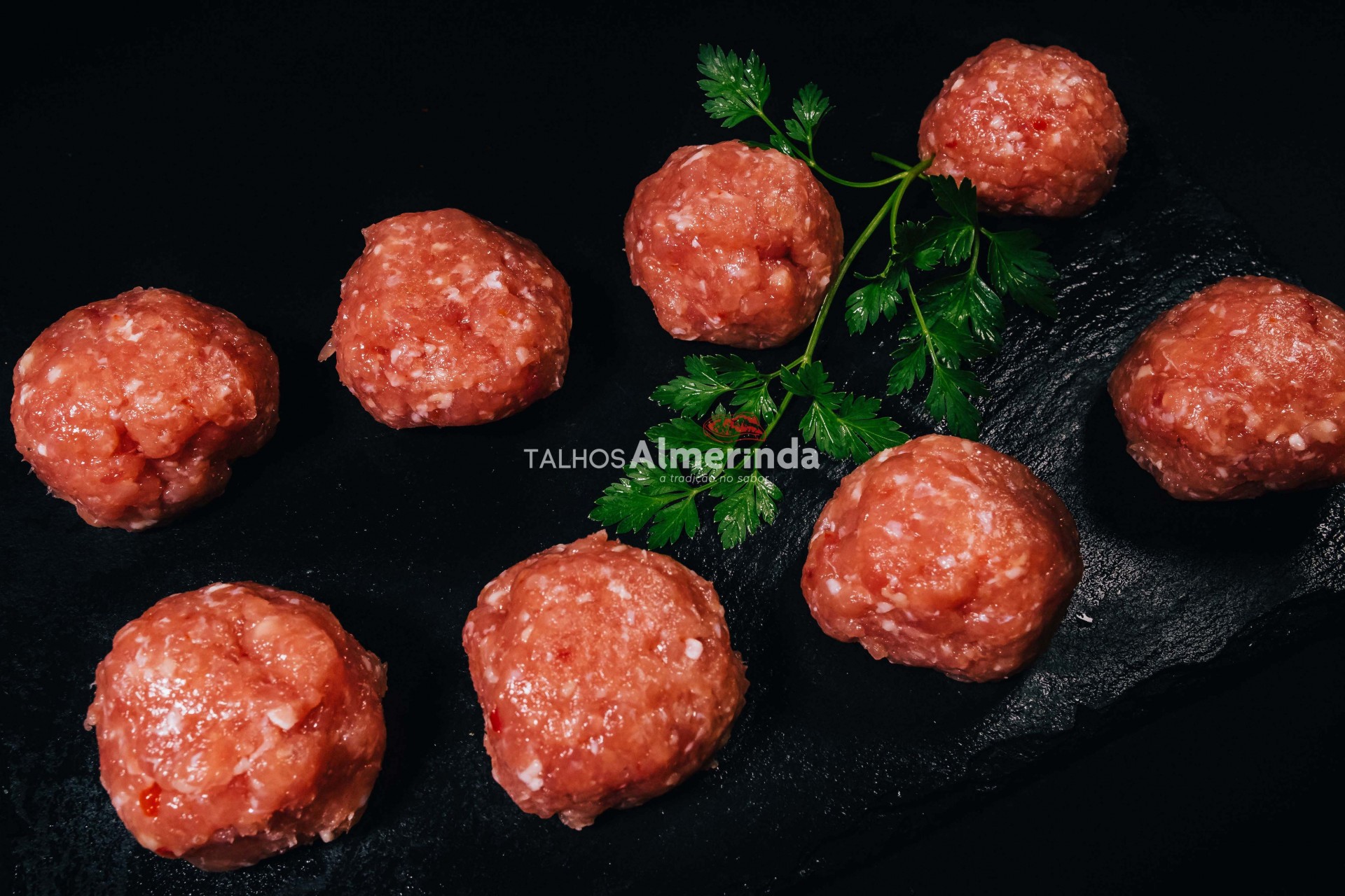 Almôndegas De Aves Oito almôndegas de carne crua com salsa em fundo preto