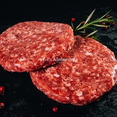 Dois hambúrgueres de carne crua com temperos vermelhos e alecrim