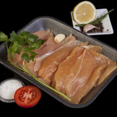 Peito de frango cru com ervas e temperos em bandeja preta