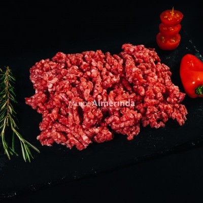 Carne moída vermelha com alecrim e pimenta em tábua preta