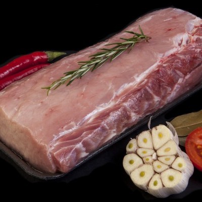 Pedaço de carne crua com alho, tomate, pimenta vermelha, alecrim e folhas de louro