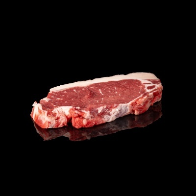 Bife cru de carne vermelha sobre superfície preta refletora