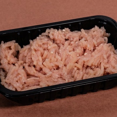 Carne picada crua em embalagem preta de plástico sobre superfície castanha