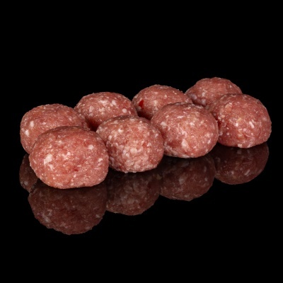 Oito almôndegas de carne crua sobre superfície preta refletora