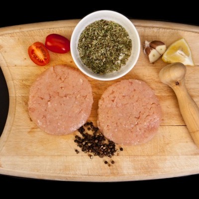 Tabua de madeira com ingredientes para hambúrguer cru