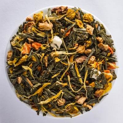 Mistura de chá verde com frutas secas e flores amarelas num prato branco