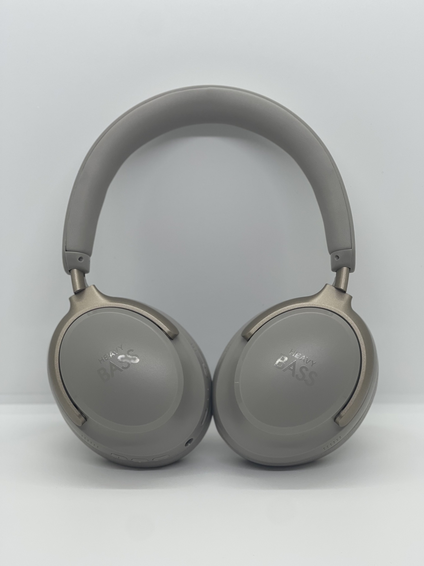 Headphones Heavy Bass 100 Ausculadores cinzentos com HEAVY BASS em relevo, fundo branco.