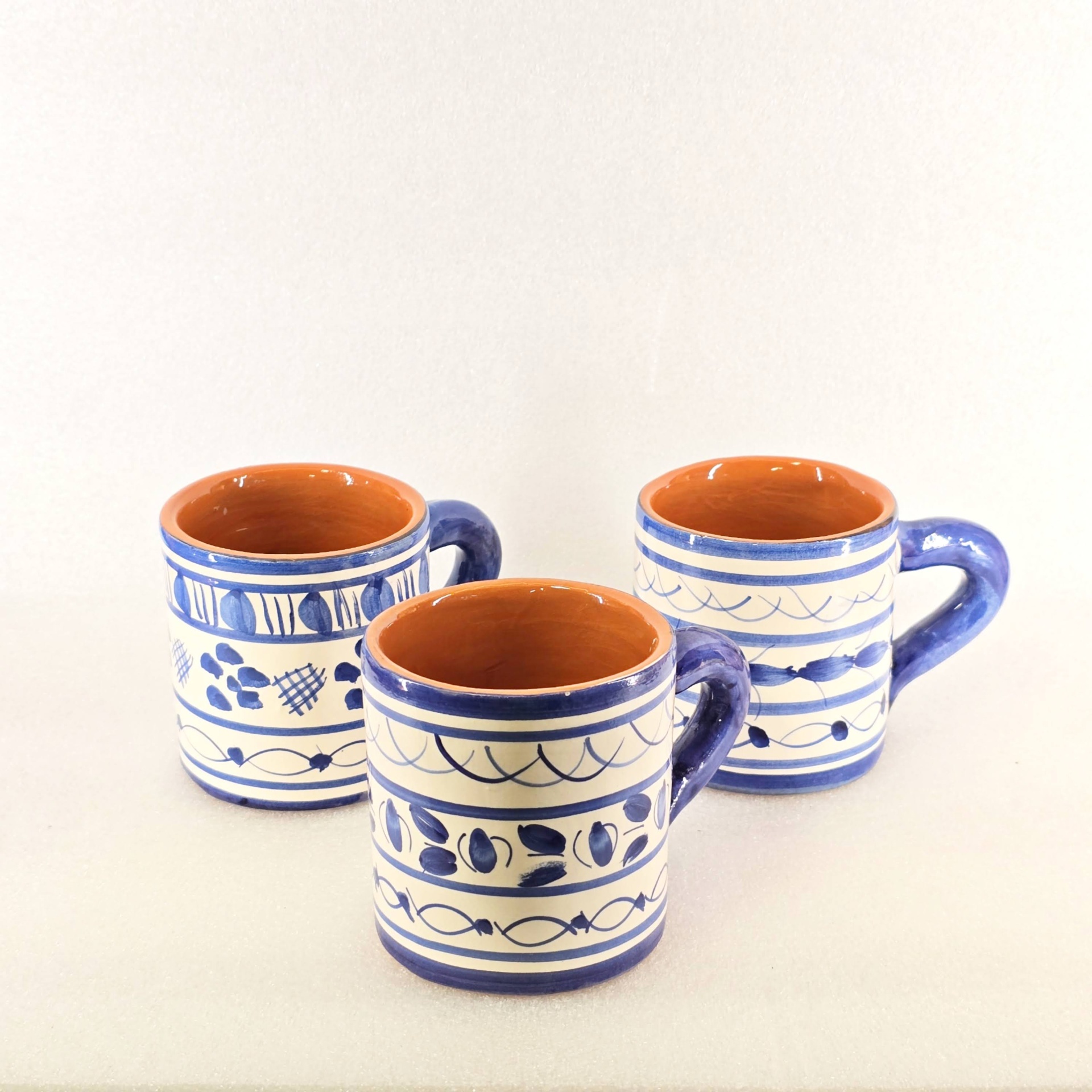Copo com Asa Três canecas de cerâmica azul e branca com padrão pintado
