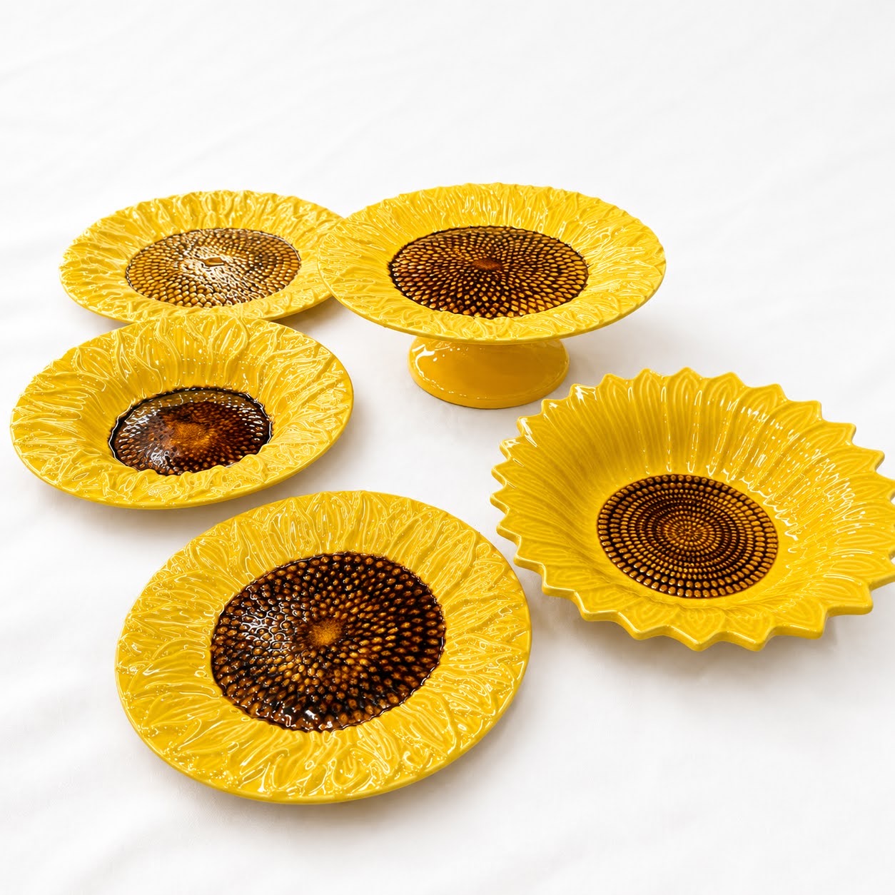 Coleção Girassóis Conjunto de pratos cerâmicos decorativos amarelos com detalhes castanhos em formato de girassol.