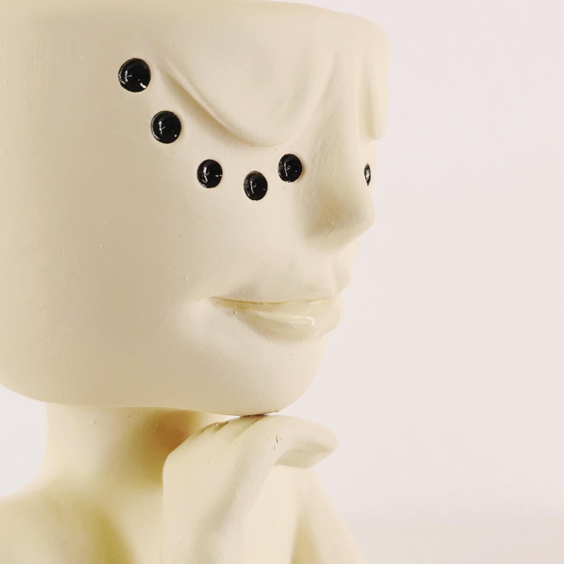 Jarra Rosto Contemplativo Escultura cerâmica rosto humano branco com pontos pretos e mão no queixo