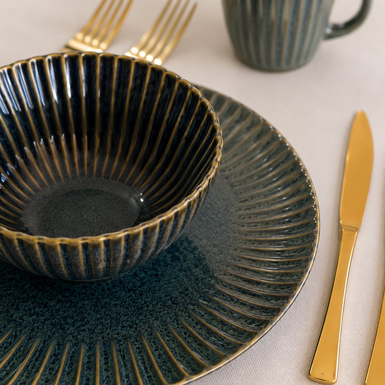 Conjunto de Louça de Mesa Azul Petróleo com Relevo Conjunto de loiça azul escuro com padrão em relevo e talheres dourados