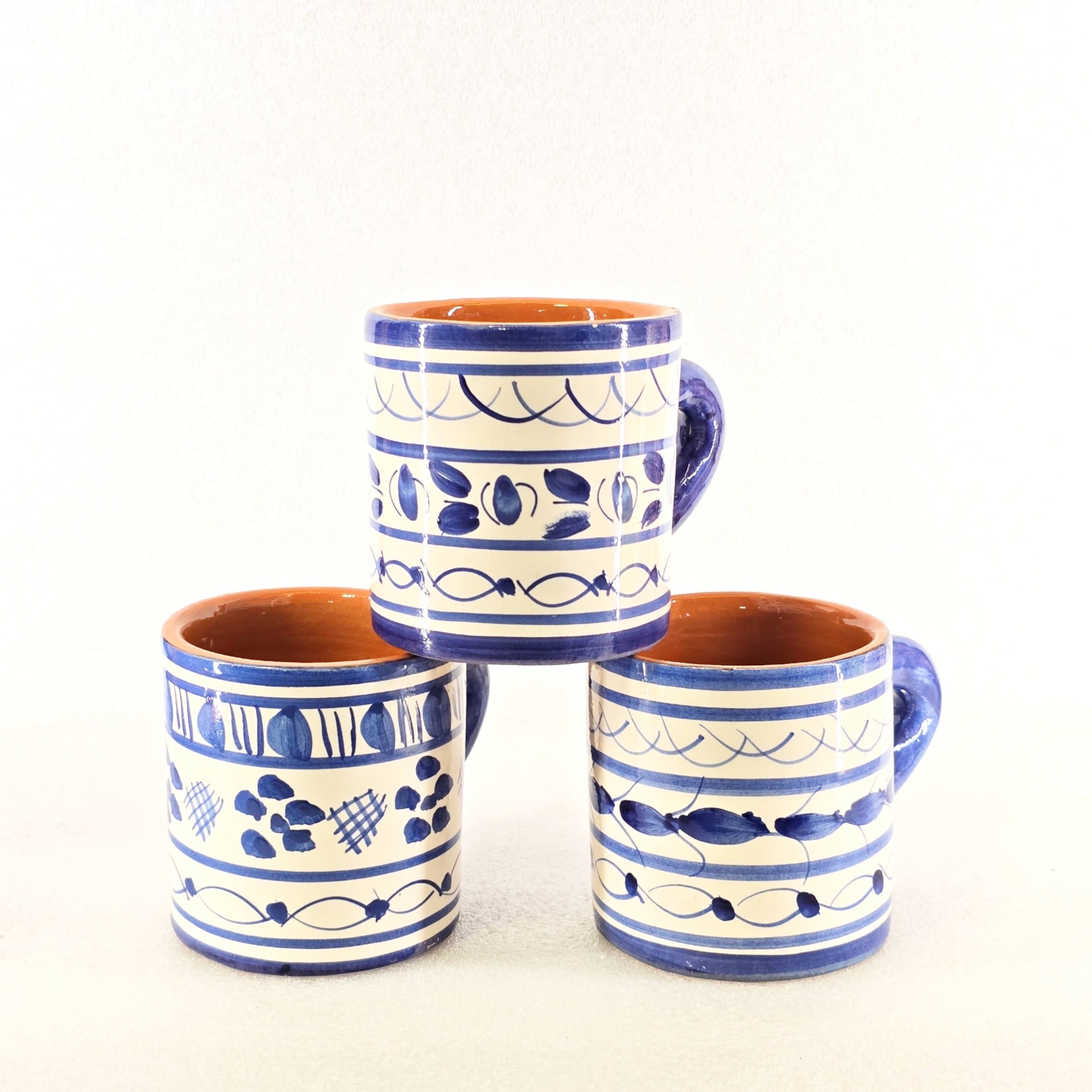 Copo com Asa Conjunto de três canecas de cerâmica branca com padrão azul e interior castanho