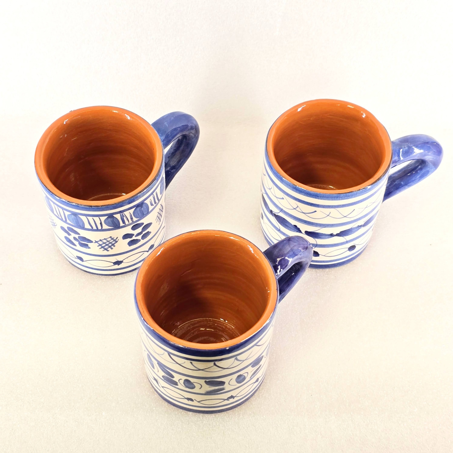 Copo com Asa Três canecas de cerâmica azul e branca com interior castanho