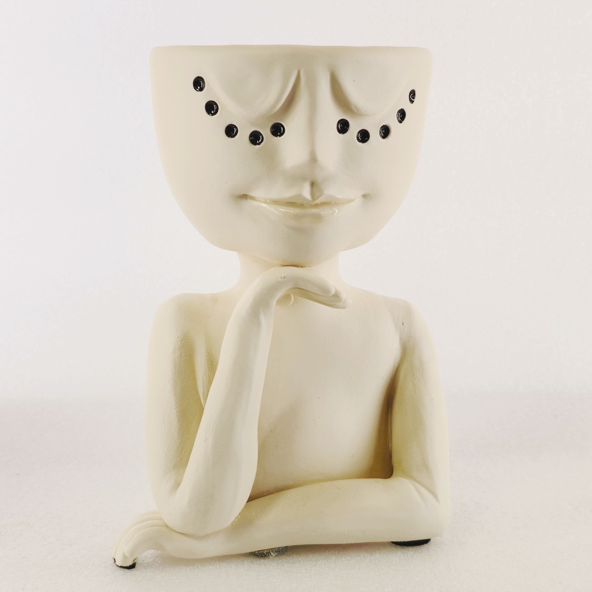 Jarra Rosto Contemplativo Vaso decorativo em cerâmica creme com braços cruzados e olhos em pontos negros.