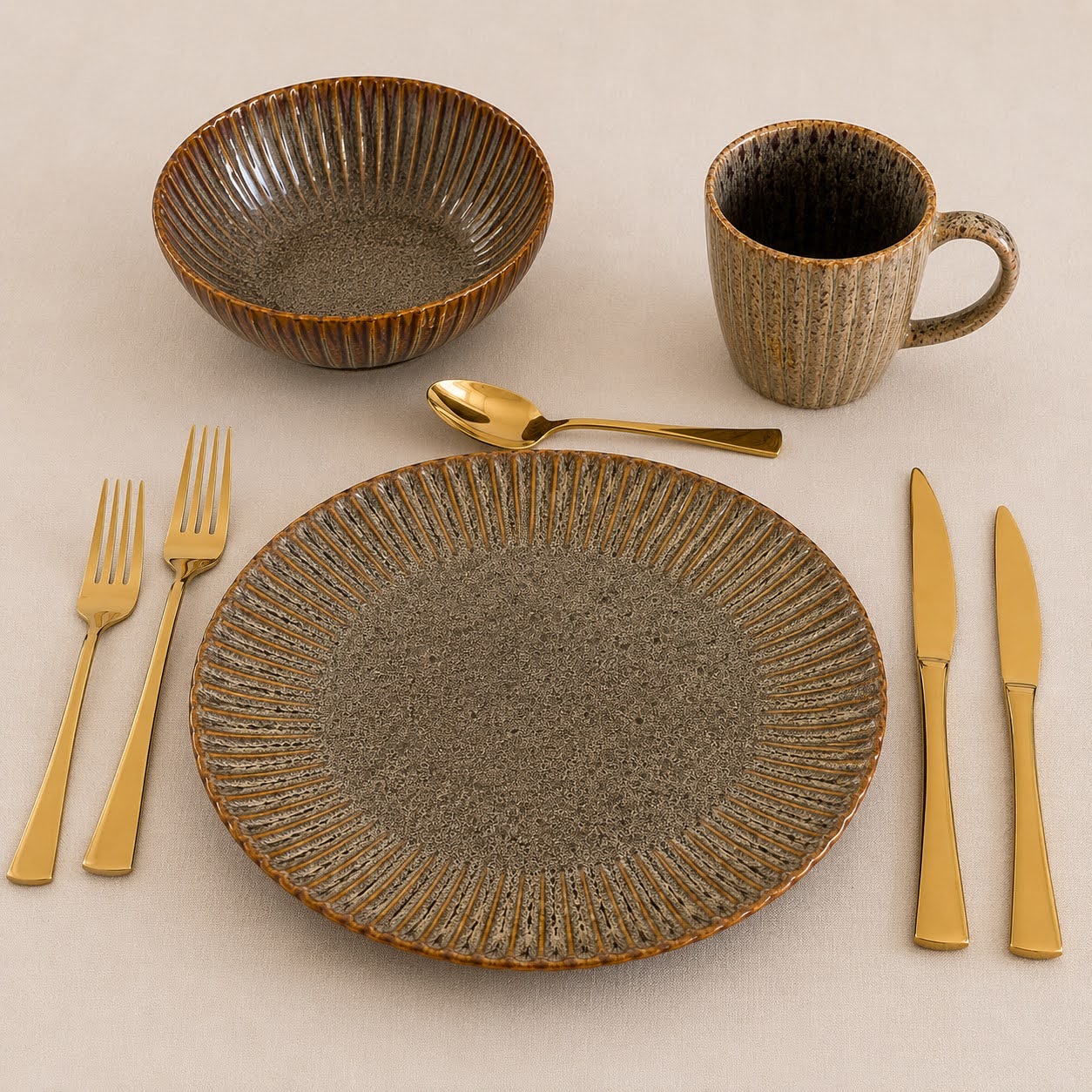 Conjunto de Louça de Mesa Castanho com Relevo Conjunto de loiça em cerâmica com talheres dourados sobre tecido bege