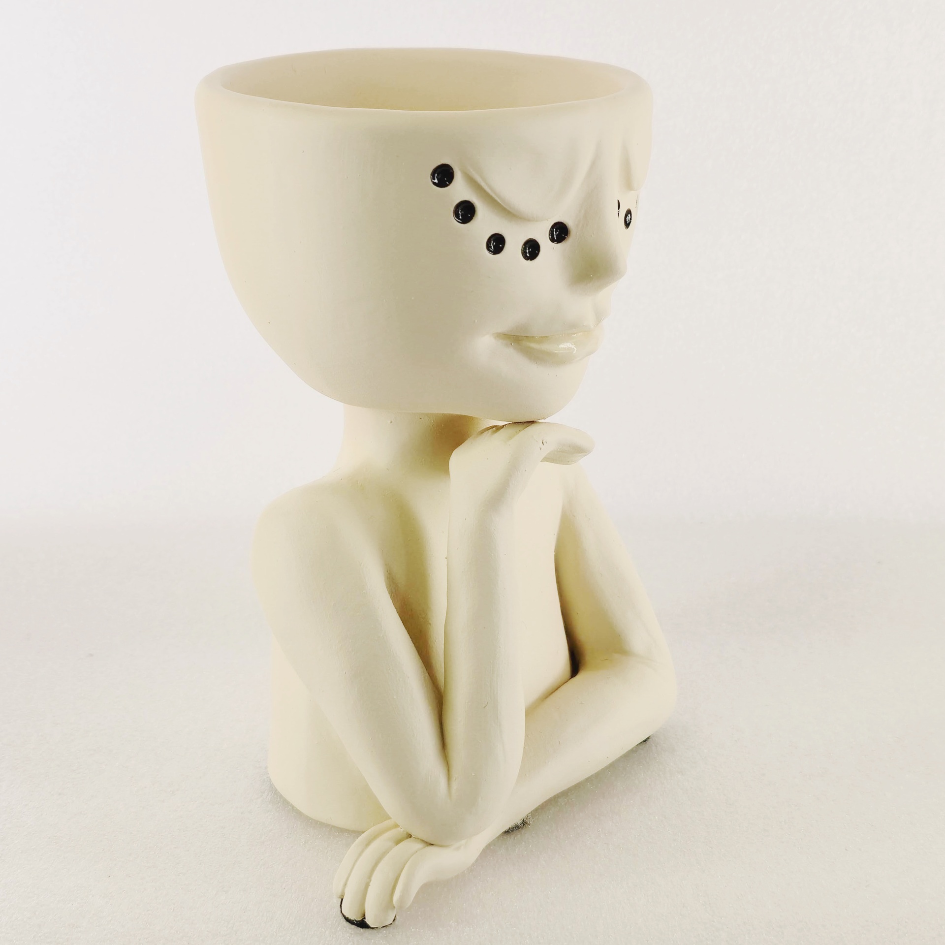 Jarra Rosto Contemplativo Vaso de cerâmica creme em forma de busto humano com olhos pretos e braços cruzados