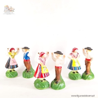 Figuras de casais a dançar vestindo roupas tradicionais coloridas sobre bases verdes