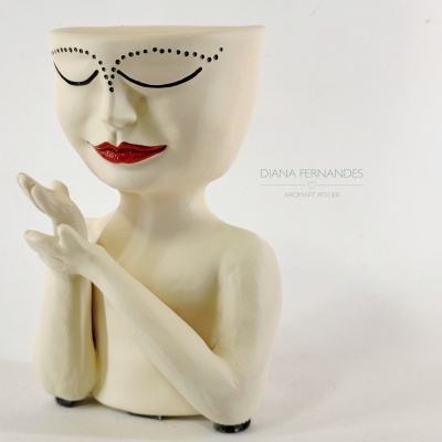 Escultura de figura humana de cerâmica creme com olhos pontilhados e lábios vermelhos