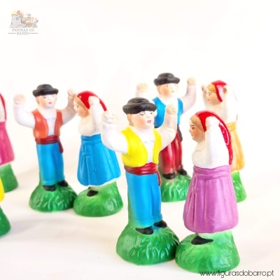 Figuras decorativas em miniatura de casais em trajes tradicionais coloridos sobre bases verdes