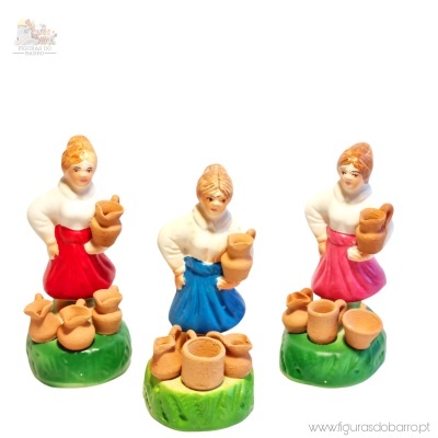 Três figuras cerâmicas de mulheres com saias coloridas e ânforas castanhas sobre bases verdes