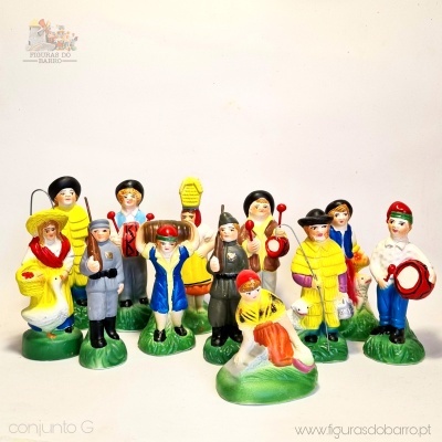 Figuras tradicionais pintadas à mão representando personagens culturais com instrumentos sobre bases verdes