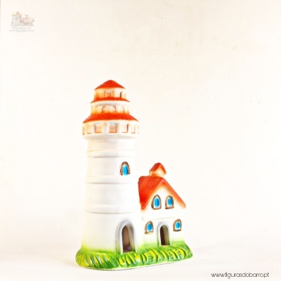 Miniatura decorativa de farol branco com telhado laranja e base verde