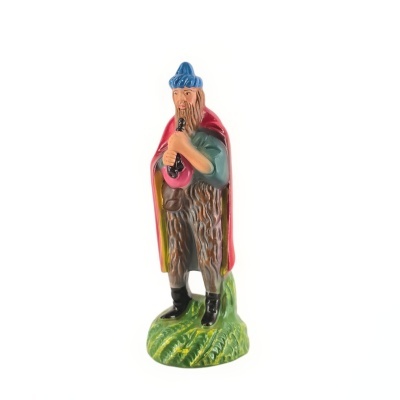 Estatueta de figura masculina com capa vermelha e chapéu azul sobre base verde