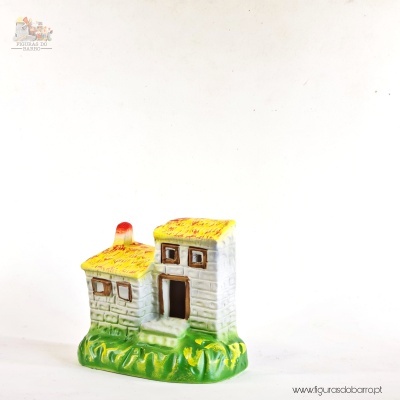Figura decorativa de casa cerâmica com base verde, paredes brancas e telhado amarelo