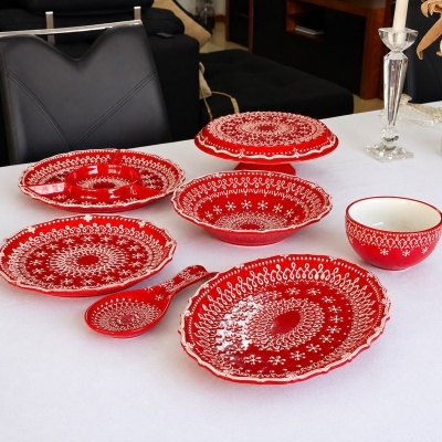 Conjunto de loiça vermelha com padrões brancos sobre mesa branca