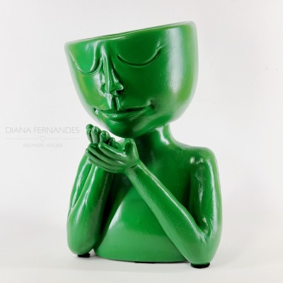 Escultura verde estilizada com cabeça em forma de vaso