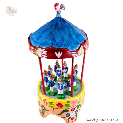 Figura de carrossel em cerâmica colorida com pequenos bonecos azuis e base amarela decorada