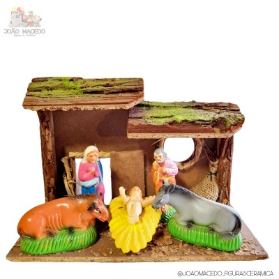 Presépio cerâmica com vaca, burro, menino Jesus, Maria e José, em estrutura estilo tronco com musgo.
