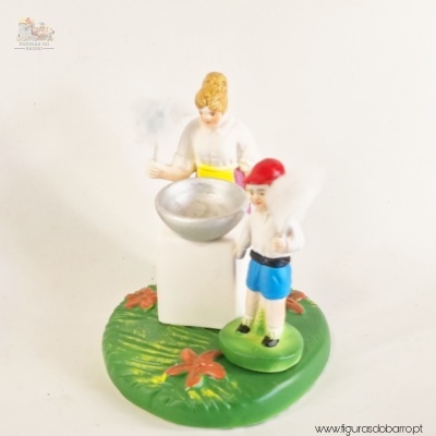 Figura decorativa de mulher e criança em cerâmica com base verde e flores