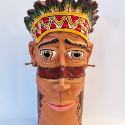 Máscara decorativa em madeira com rosto pintado e penas coloridas