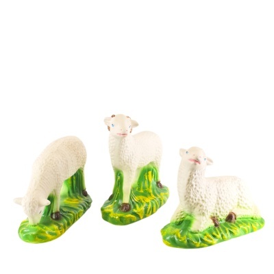 Três estatuetas de ovelhas brancas em cerâmica com bases verdes que simulam relva