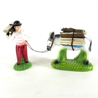 Figura decorativa de homem e burro com carga de madeira sobre bases verdes