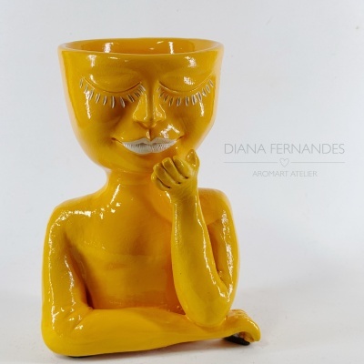Vaso cerâmico amarelo estilizado em forma de figura humana com olhos e lábios pintados