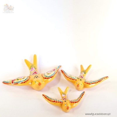 Três pássaros decorativos amarelos com pinturas coloridas