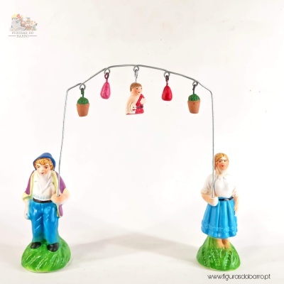 Figura decorativa cerâmica casal em baloiço com enfeites e base verde